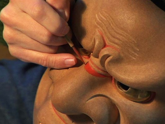 ジーンズをはいた面打・新井達矢。木の塊から能面が生まれる瞬間を描いた『面打 / men-uchi 』